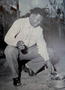 Nelson Mandela burns his pass in a small metal pot.