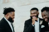 Three men laughing in tuxedos.