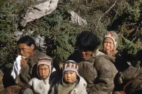 A group of women and children sitting together. The two children in the front are looking at the camera.