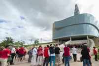 A group of people watching a choir as they perform on the Museum’s exterior amphitheater. 