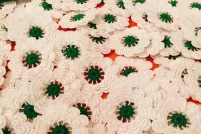 A bunch of knit white flowers with green pistils. 