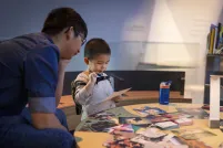 A child and adult looking at a photograph.