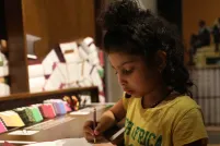 Girl writing with a pencil on paper