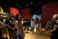 People standing listening to a Museum guide.