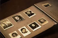 An open photo album contains black-and-white headshots of seven individuals and other annotated photos