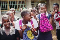 Girls holding Days for Girls Sewing Bee menstrual product bags.