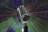 An antique chrome-plated microphone in the centre of the image is encircled by multicoloured rays over a mottled blue and green background.