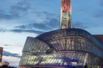 An unusual building features a glowing red tower atop a "cloud" of hundreds of glass panes.