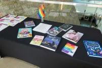 A table with a black tablecloth and colourful books relating to 2SLGBTQI+