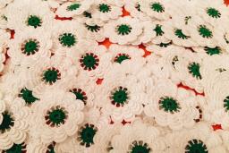 A bunch of knit white flowers with green pistils. 