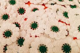 A bunch of knit white flowers with green pistils.
