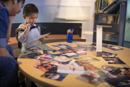 A child and adult looking at a photograph.