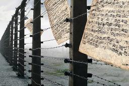 A person walking by a barbed-wire fence. Sheet music is caught in the wire.