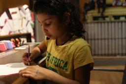 Girl writing with a pencil on paper