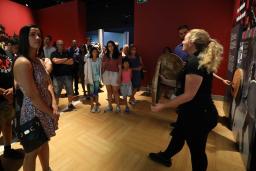 People standing listening to a Museum guide.