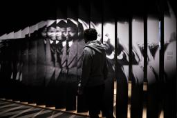 A person walks in front of a large photograph of Nelson Mandela.
