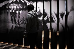 A person walks in front of a large photograph of Nelson Mandela.