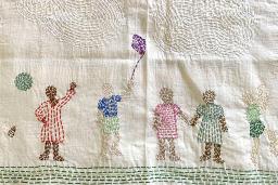 A piece of stitched fabric portraying families in diverse cultural clothing engaged in happy activities.