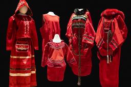 5 red dresses of different sizes and designs are displayed on mannequins.