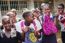 Girls holding Days for Girls Sewing Bee menstrual product bags.