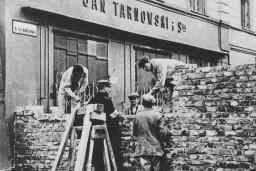 A group of men building a stone wall across a city street