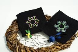 Two outline beading flowers with two tobacco ties on a dream catcher.