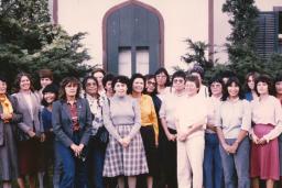 A group of Indigenous women nurses stand together outside.