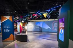 A museum gallery featuring artwork projected onto large screens and colourful geometric shapes.