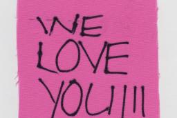 Piece of cloth with "We love you!!!" written.