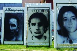 Outdoor display of large photographs of people’s faces.