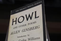 A book on display. The cover reads: The Pocket Poets Series. Howl and Other Poems. Allen Ginsberg. Introduction by William Carlos Williams. Number Four.