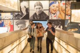 A group of young adults talk excitedly while walking up a set of illuminated ramps.