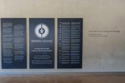 Large dark blue panels with white text and graphics displayed in the Community Corridor at the Canadian Museum for Human Rights. The centre panel features a circular logo and commemorates the 40th anniversary of the Canadian Centre for Child Protection. The two panels on either side present bilingual text in English and French.