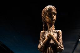 A statue of a young girl clutching stalks of wheat.