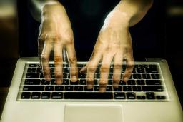 An image of transparent hands hovering over a keyboard.