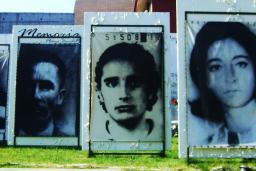 Outdoor display of large photographs of people’s faces.