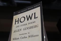 A book on display. The cover reads: The Pocket Poets Series. Howl and Other Poems. Allen Ginsberg. Introduction by William Carlos Williams. Number Four.