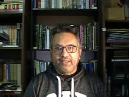 A man sitting in front of a bookshelf.