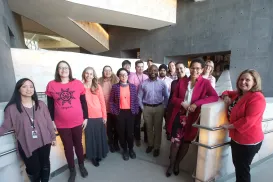 15 members of the Museum staff, smiling at the camera, clustered on an alabaster ramp in daylight.