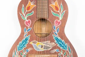 An acoustic guitar decorated with painted patterns.