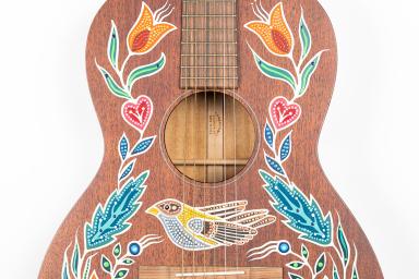 An acoustic guitar decorated with painted patterns.