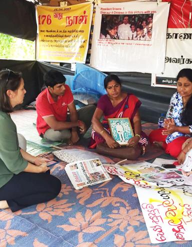 In the Sri Lankan city Vavuniya in 2017, Elaine Pearson meets with Tamil mothers protesting the enforced disappearance of their children during Sri Lanka's civil war. Partially obscured.