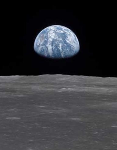 View of earth rising above the lunar horizon, showing the blue and white planet against the dark backdrop of space as seen from the moon’s surface. Partially obscured.