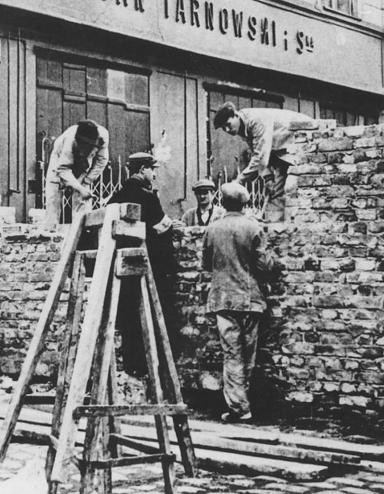 A group of men building a stone wall across a city street