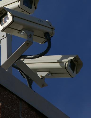 Three surveillance cameras on the corner of a building