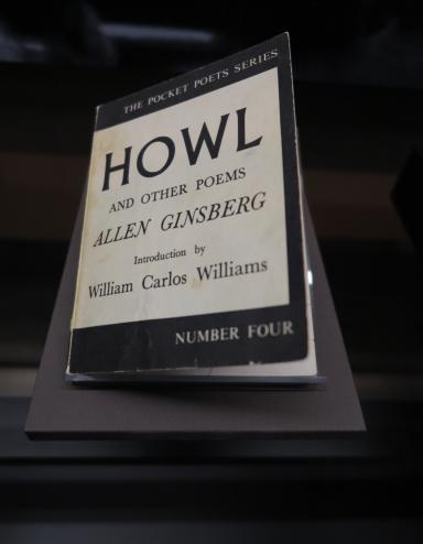 A book on display. The cover reads: The Pocket Poets Series. Howl and Other Poems. Allen Ginsberg. Introduction by William Carlos Williams. Number Four.