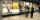 Museum visitors observe a glass display containing images and objects.