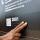 A hand touches braille letters on a museum exhibit.
