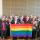Twenty-eight members of the LGBT Purge Fund Board and LGBTQ2+ National Monument Advisory Committee standing together and holding a rainbow flag, at the first Monument visioning session in 2019.