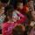 A group of children with playfully painted faces laughing and gesturing.